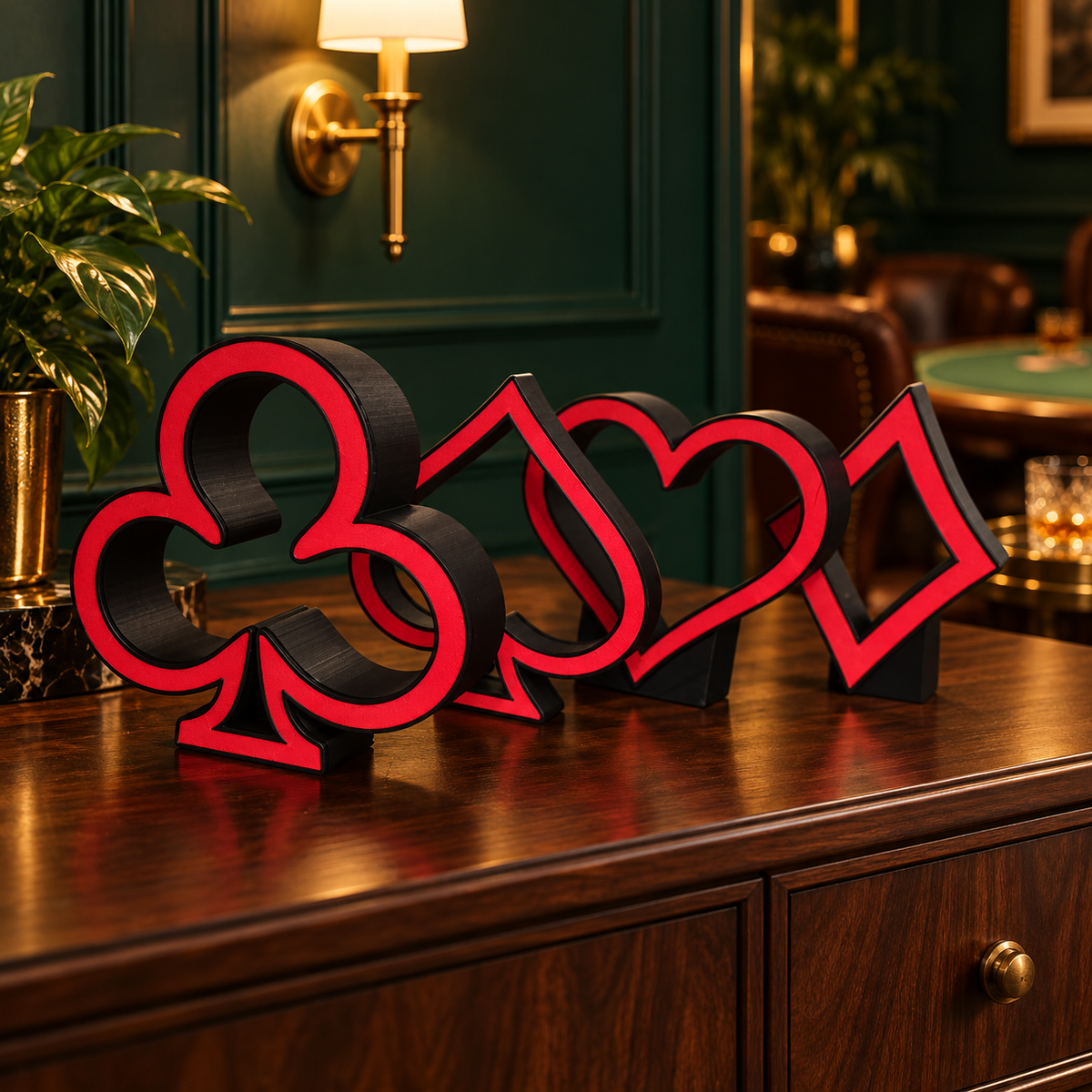 Four red and black card suit tabletop lights on a walnut console against an elegant emerald lounge backdrop, styled product photo