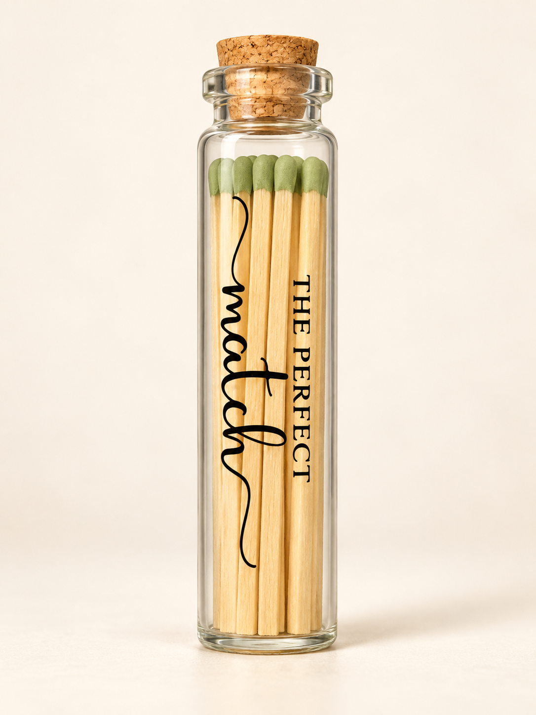 The Perfect Match glass bottle with green tipped matches resting at the base