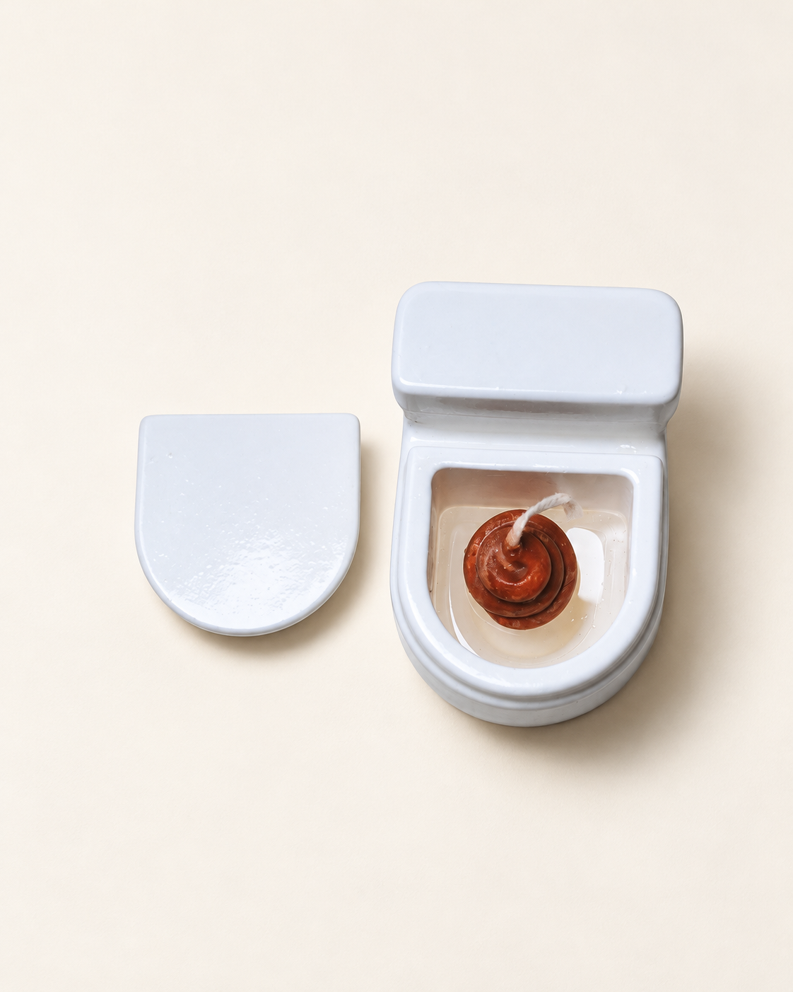 Poo in the Loo Candle with lid removed, showing brown spiral wax candle and wick inside